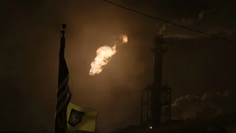 Flame smoke stack with American flag in foreground Stock Footage 89945338