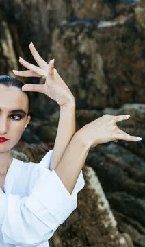 Flamenco dancer hand pose with partial portrait by the sea Stock Photos