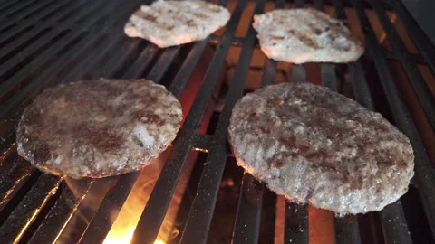 Flames and smoke in slow motion of hamburgers and chicken burgers on a hot grill Stockbeeldmateriaal 337182294