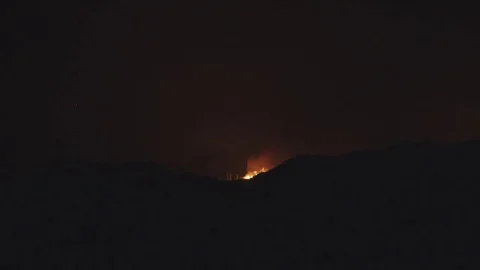 Flames appearing over ridgeline Stock Footage 79606493