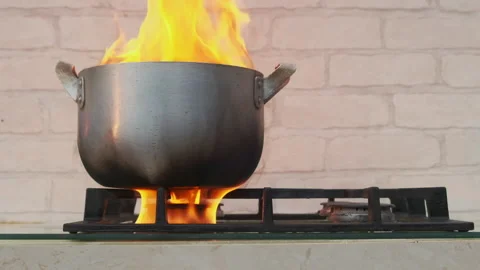 Flames of burning food inside pot left forgotten on gas stove in kitchen Video stock 157414760