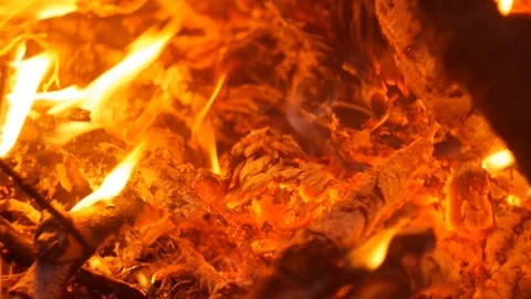 Flames, coals from the fire, warm hands in the background Stock Footage 122610315