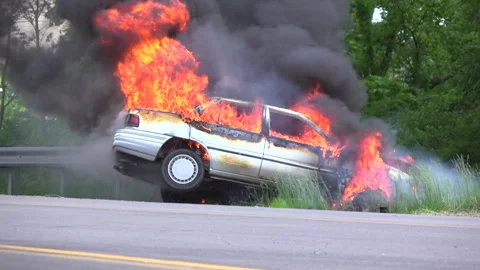Flames coming from burning car on side of road 4k Видео 139525078