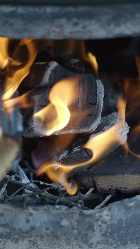 Flames dancing in a charcoal fire pit at night Stock Footage 336702515