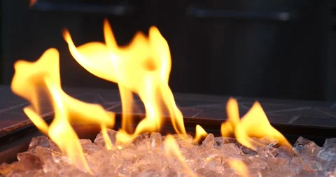 Flames dancing on ice crystals in a modern fire pit installation Stock Footage 281815846