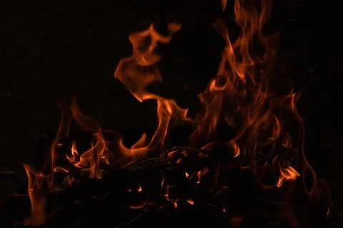 Flames in the dark, a bright fire on a dark background, fire close up Stock Photos