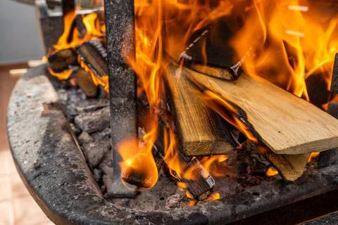 Flames in different forms of a bonfire made with orange tree trunks Stock Photos