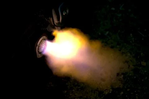 The flames of an engine backfiring through its exhaust pipe. Stock Photos