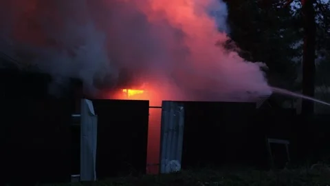 Flames Engulf Structure as Firefighters Battle a House Fire in the Early Evening Stock Footage 321935039