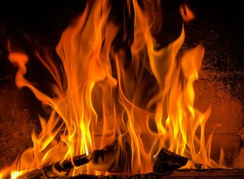 Flames of fire and hot coals of burned wood in the fireplace Stock Photos