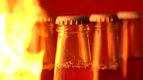 Flames of fire erupt from different sides of five glass bottles in the dark Stock Footage 149426556