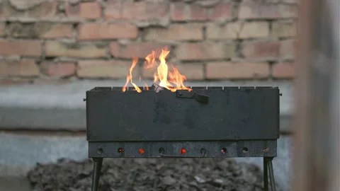 Flames of fire in a slow motion going out of metal barbecue Stock Footage 196245339