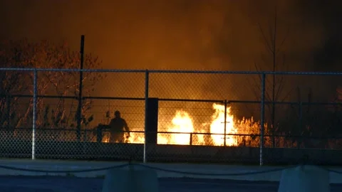 Flames with firefighter seen from far away Stock Footage 139658751