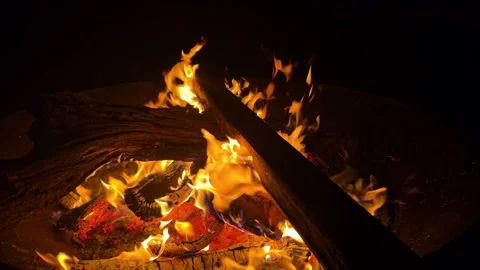 Flames flicker and dance around wood as evening fire creates a warm atmosph.. Stock Footage 296498529