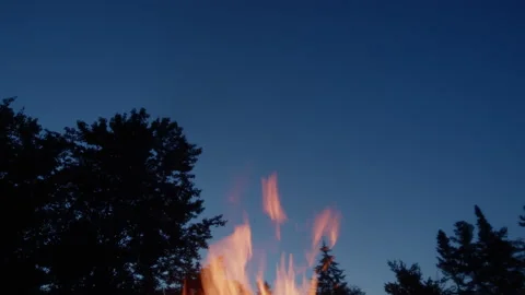 Flames in front of a dark blue sky Stock Footage 157644951