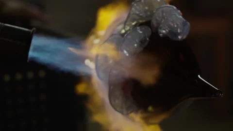 Flames on the glass as it turns while being molded Stock Footage 275463329