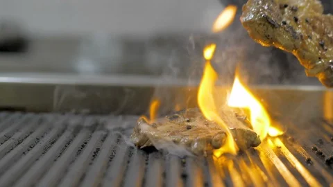 The flames in the kitchen of the restaurant. The chef prepares a steak flambe Stock Footage 125070918
