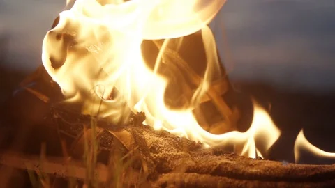 Flames lick the surface of the sneakers. Bright fire illuminates the dark night Stock Footage 95910271