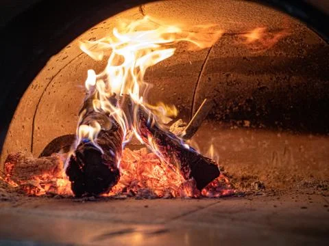 Flames, logs, ashes, embers inside wood burning pizza oven Stock Photos