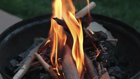 Flames over burning wood in a backyard fire pit Stock Footage 327700630
