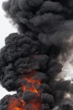 Flames of red-orange fire, motion clouds of black fumes covered sky Photos