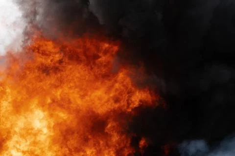 Flames of red-orange fire, motion clouds of black fumes covered sky Photos