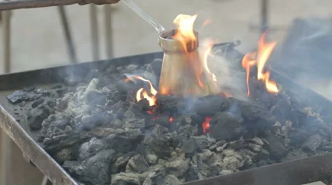 Flames rising above hot coals, covering pot with brewed coffee Stock-Footage 7769201