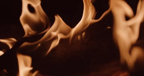 Flames roll off a charred cracked board in foreground Stock Footage 102789916