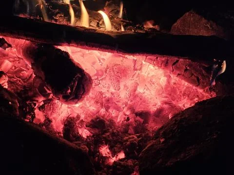 Flames of a stone pit fire at night in dark background at a campground Stock Photos