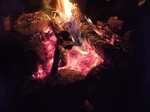 Flames of a stone pit fire at night in dark background at a campground Foto stock