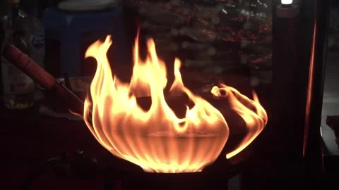 Flames from the wok dance in slow motion at night. Video stock 290953354