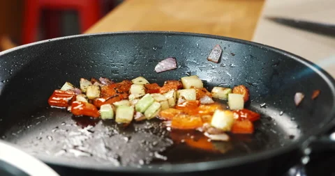 Flaming, burning vegetables that are cooking in pan, frying veggies. Zucchini Stock Footage 133392330