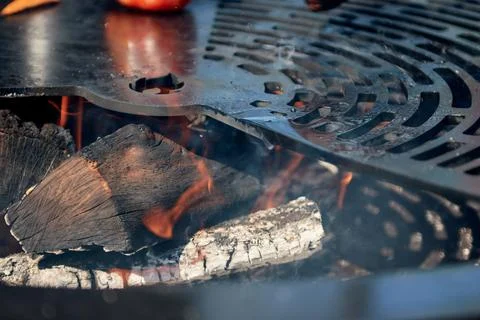 Flaming Charcoal In Kettle Grill Pit with Cast Iron Grid. Round table-cooking Stock Photos