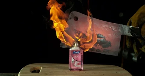 Flaming Hatchet Cuts Bottle of Hand Sanitizer Stock Footage 77782458