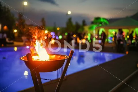 Flaming torch at sunset by the pool Stock Photos