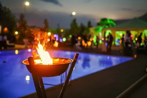 Flaming torch at sunset by the pool Stock Photos