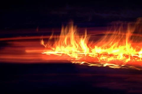 Flammen Lodernde Flammen auf einer Oelspur. Bewegungsunschaerfe, Querforma... Stock Photos