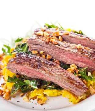 Flank steak with mashed plantain , collard greens and ginger peanuts Stock Photos