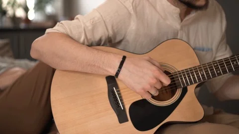 Flare effect. Slow motion. Acoustic guitar and sunlight. A guy in a beige shirt  Stock Footage 127485306