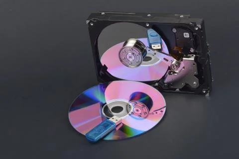 Flash card lying on a disk and a opened hard disk on  dark grey background Stock Photos