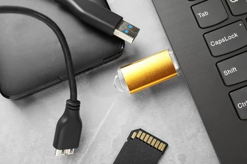 Flash drive connected to laptop, SD memory card and external hard disk on g.. Stock Photos