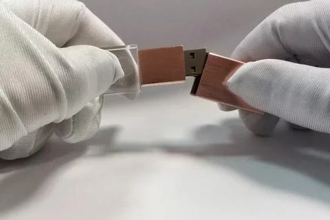 Flash drive in hands in white gloves. Storage of information on flash drive. Foto stock