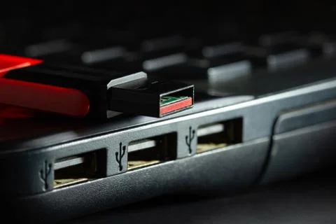 Flash drive in USB port of computer notebook in darkness. Stock Photos