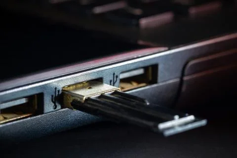 Flash drive in USB port of computer notebook in darkness. Stock Photos
