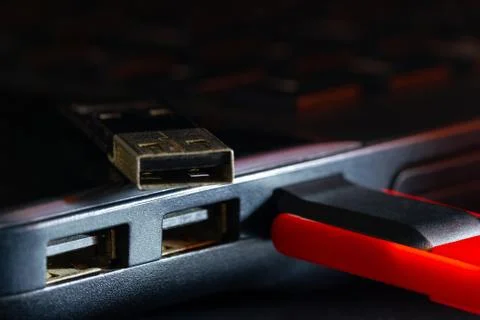 Flash drive in USB port of computer notebook in darkness. Stock Photos