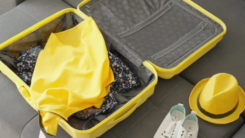 A flash of frantic packaging where a young woman packs her things in a suitcase Stock Footage 242502188