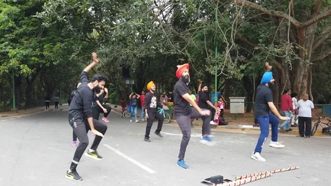 A flash mob dancing to a song in Cubbon park on a bright day Stock Footage 129811315