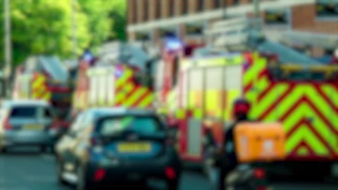 Flashing blue lights on blurred fire brigade vehicles behind civilian cars in Video stock 342334630