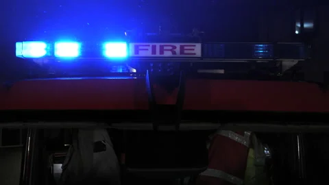 Flashing blue lights on a fire engine truck during an emergency. UK Stock Footage 330399292