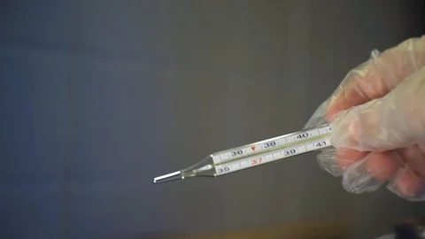 Flashing light and a thermometer with a high temperature in a hand in a whit Stock Footage 123770808